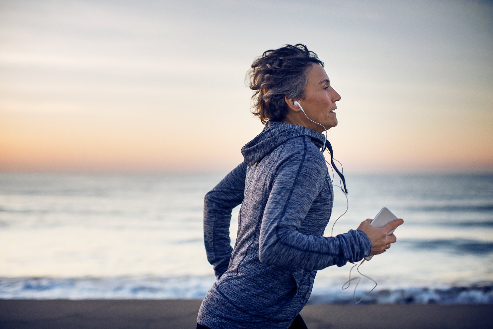 A woman running along the coast at first light